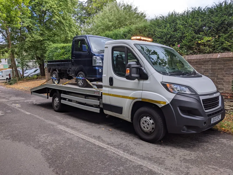 Small commercial vehicle loaded onto MotorMoves recovery truck for professional UK transport