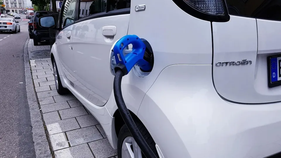 Electric car connected to a charging cable before a vehicle delivery journey